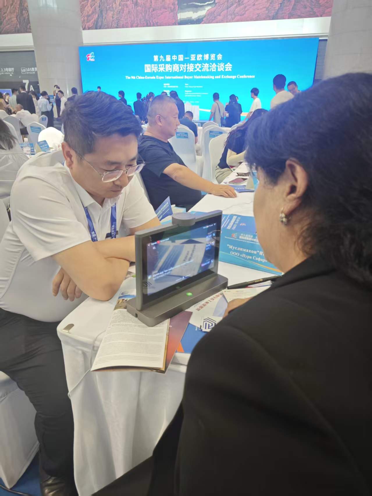 An overseas participant using an IM Mate translator at China-Eurasia Expo
